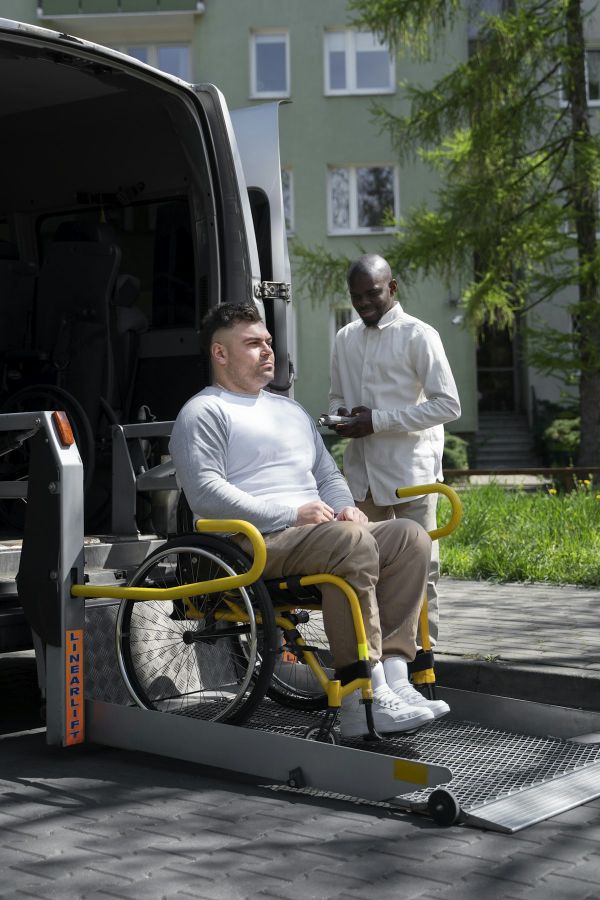 Wheelchair lift in operation at the rear of an accessible vehicle